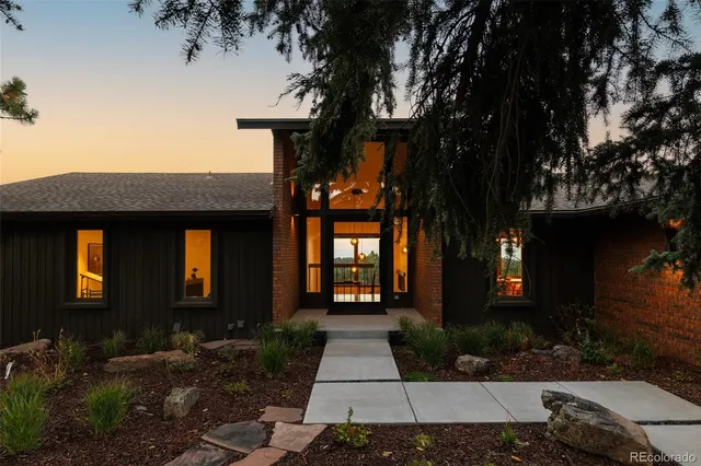 a living room with furniture large windows and a fireplace