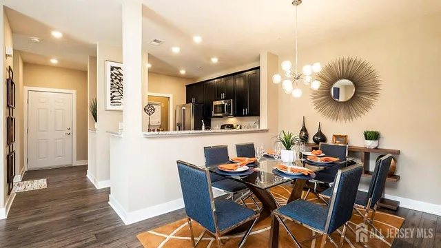 a dining room filled chandelier and wooden floor