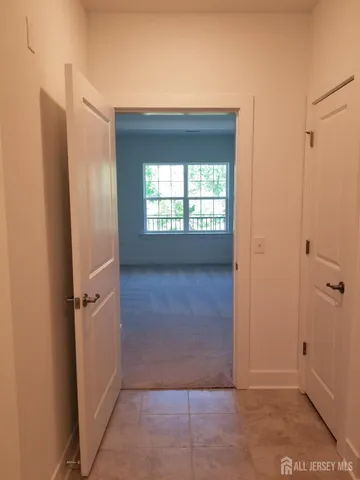 a view of a hallway with windows and closet