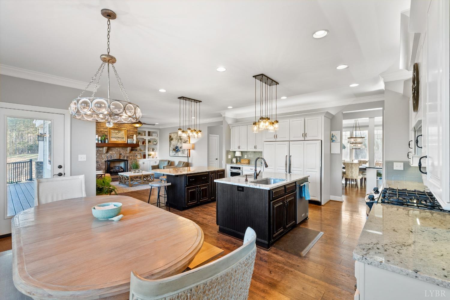 1249 Lees Mill Lane Goode, VA 24556 - Photo 17 of 98 a kitchen with stainless steel appliances kitchen island granite countertop a stove a refrigerator a oven a dining table and chairs with wooden floor