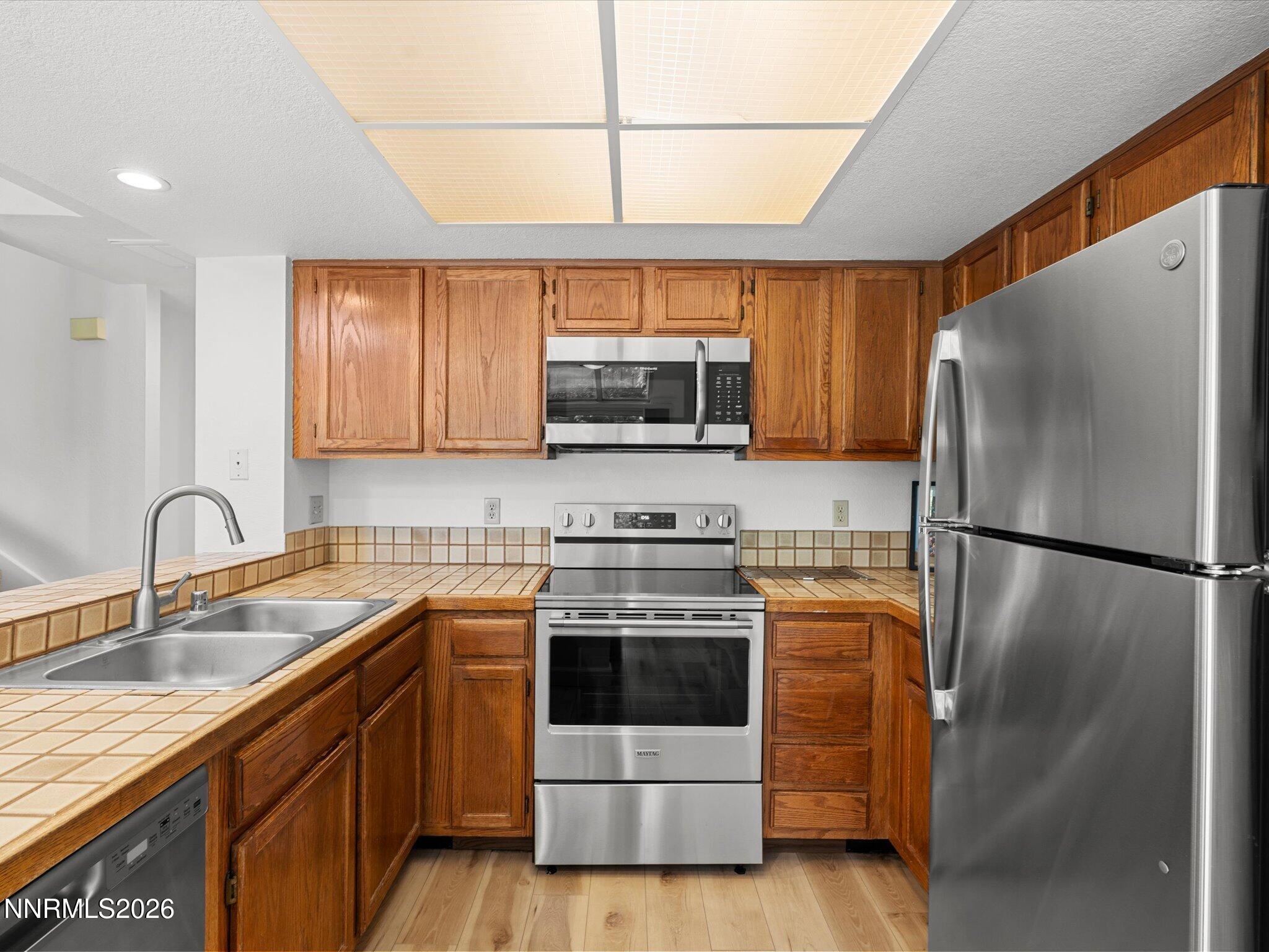3170 Oakshire Court Reno, NV 89509 - Photo 20 of 43 a kitchen with stainless steel appliances a refrigerator sink and microwave