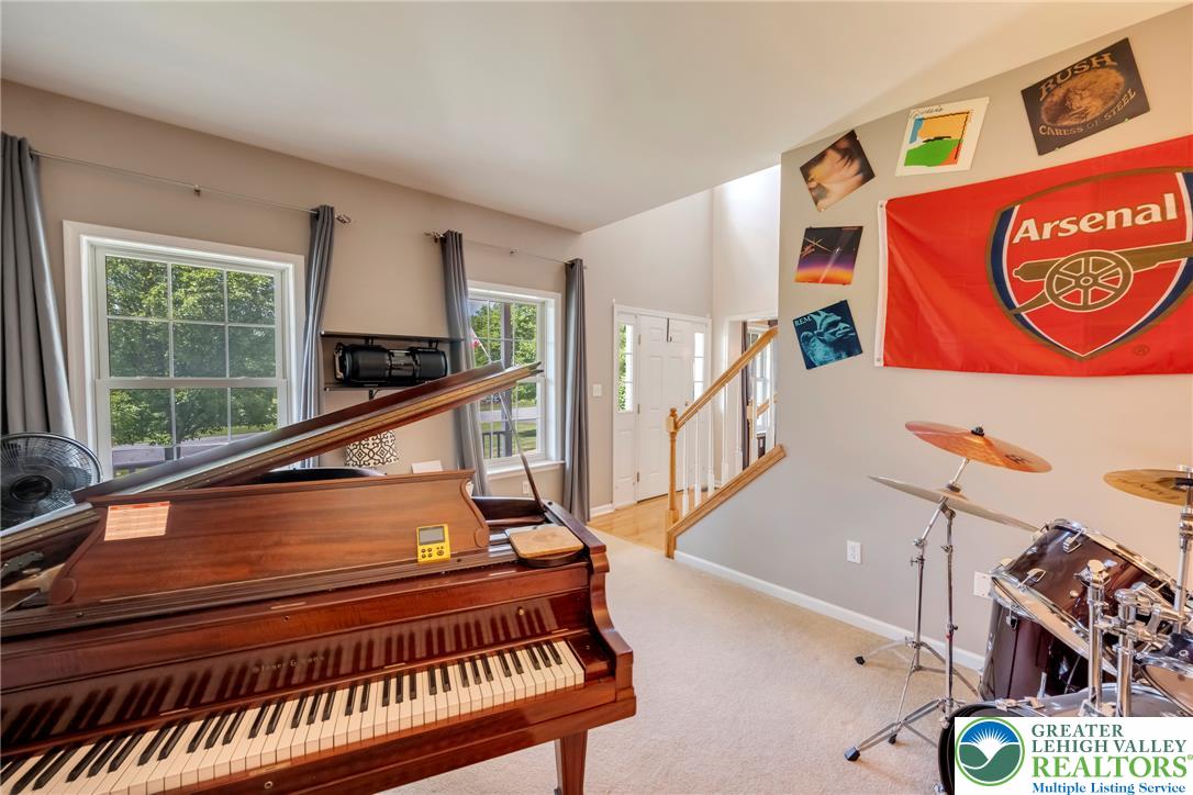 204 Bushkill Ridge Road Wind Gap, PA 18091 - Photo 22 of 48 A grand piano takes center stage in this inviting living area, bathed in natural light from tall windows.