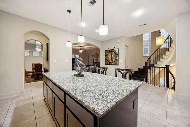 a kitchen with granite countertop a sink a counter top space and living room view