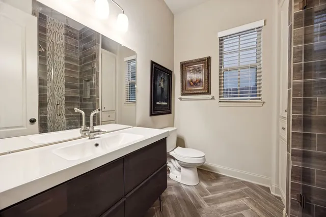a bathroom with a sink toilet a mirror and shower