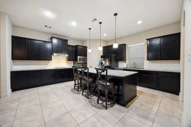 a kitchen with stainless steel appliances kitchen island granite countertop a sink counter space and cabinets