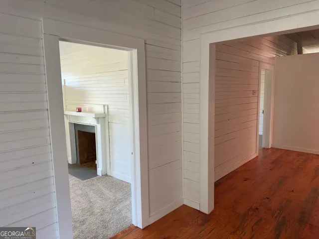 a view of a room with wooden floor and white walls