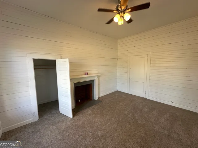 a bathroom with a granite countertop toilet a sink a mirror and shower