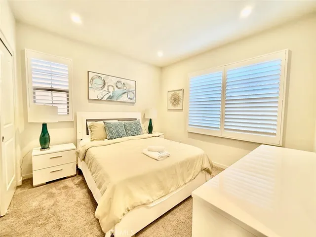 a bedroom with a bed and a large window