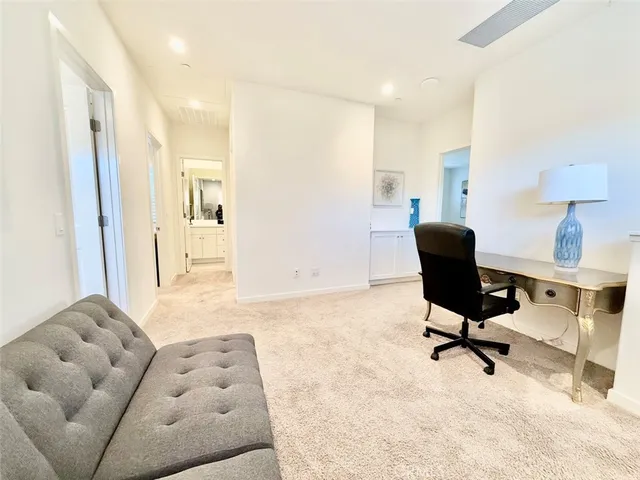 a livingroom with workspace couch and a window