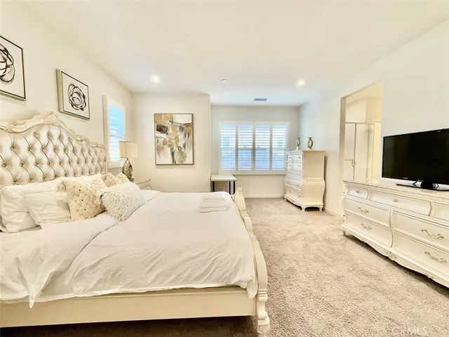 a bed room with a bed a television and dresser