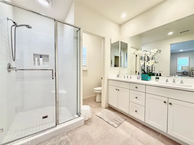 a spacious bathroom with a shower sink and mirror
