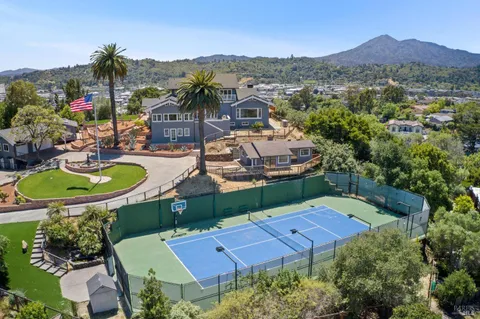 an aerial view of a house with swimming pool a yard and mountain view