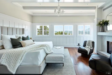 a bedroom with furniture and a large window