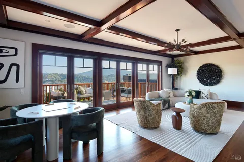 a living room with couches a table and chairs with a large window