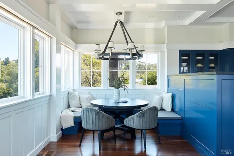 a dining room with wooden floor and chandelier