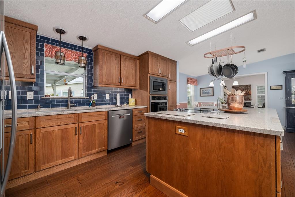 706 Starboard Avenue Edgewater, FL 32141 - Photo 12 of 35 a kitchen with stainless steel appliances granite countertop a sink stove and wooden cabinets