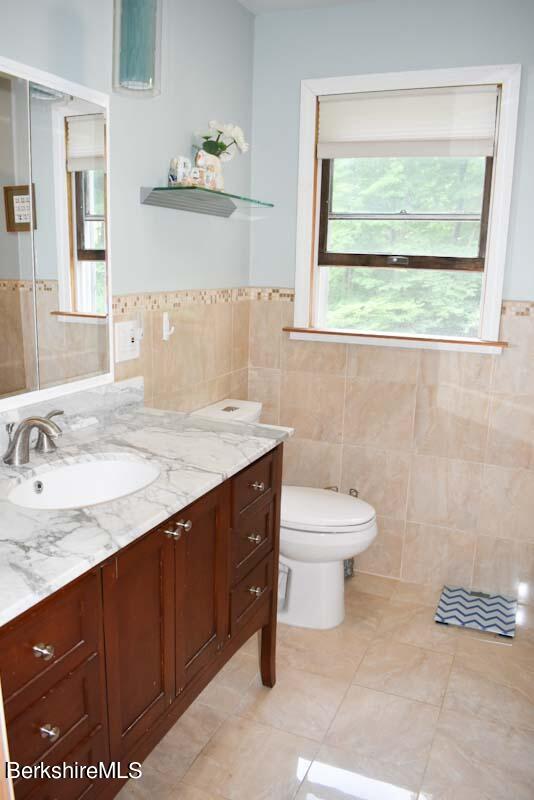 488 Summit Road Richmond, MA 01254 - Photo 35 of 44 a bathroom with a granite countertop sink toilet and a window