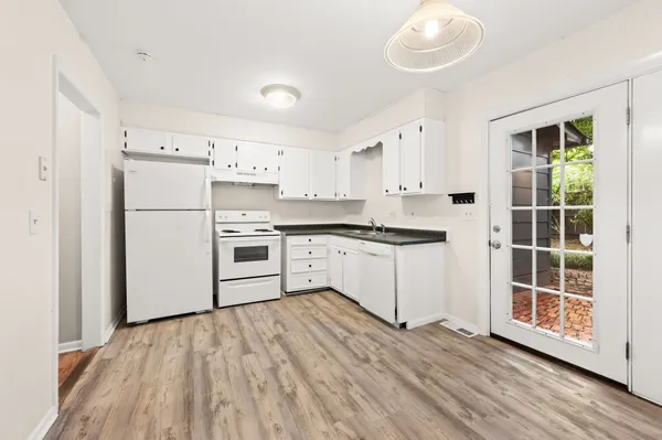a kitchen with granite countertop white cabinets and white appliances