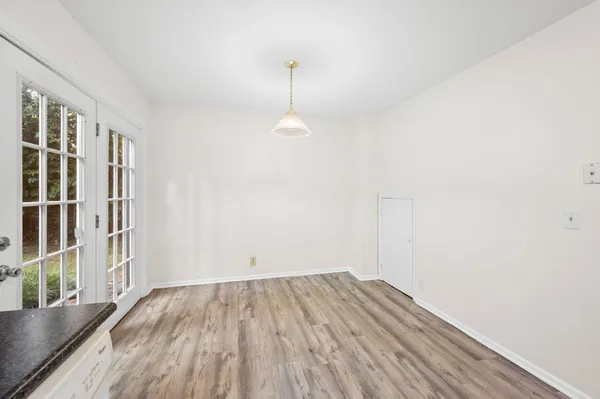 a view of a room with wooden floor and windows