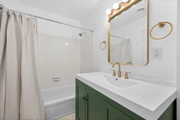 a bathroom with a sink vanity and a mirror