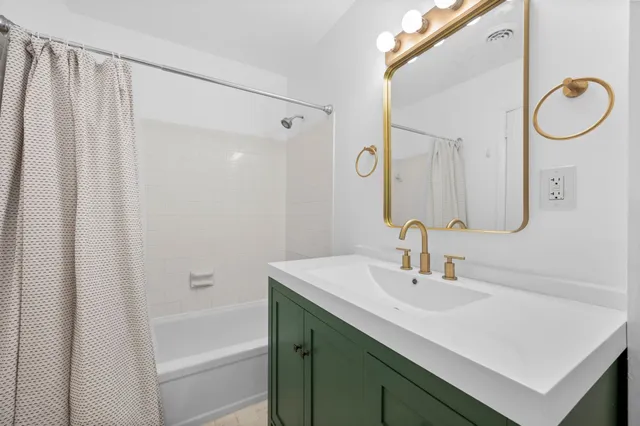 a bathroom with a sink vanity and a mirror