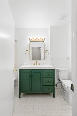 a bathroom with a double vanity sink mirror and toilet