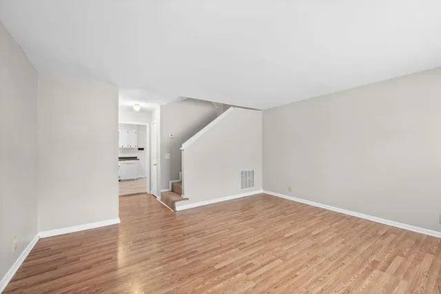 a view of empty room with wooden floor