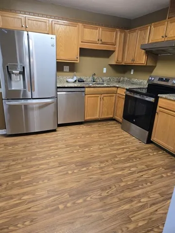a kitchen with stainless steel appliances granite countertop a refrigerator sink and cabinets