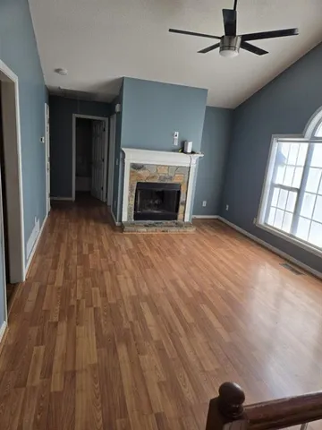 wooden floor fireplace and windows in an empty room