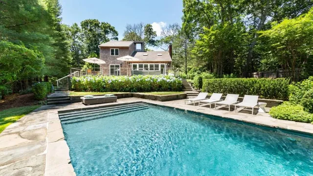 a view of a house with pool and a chairs