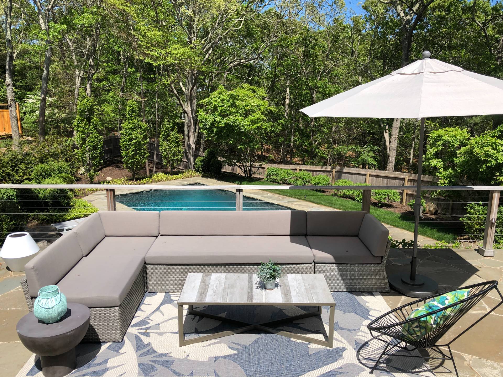 10 Scallop Avenue East Hampton, NY 11937 - Photo 18 of 23 a view of a patio with couches table and chairs under an umbrella with a barbeque