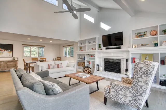 a living room with furniture a fireplace and a flat screen tv