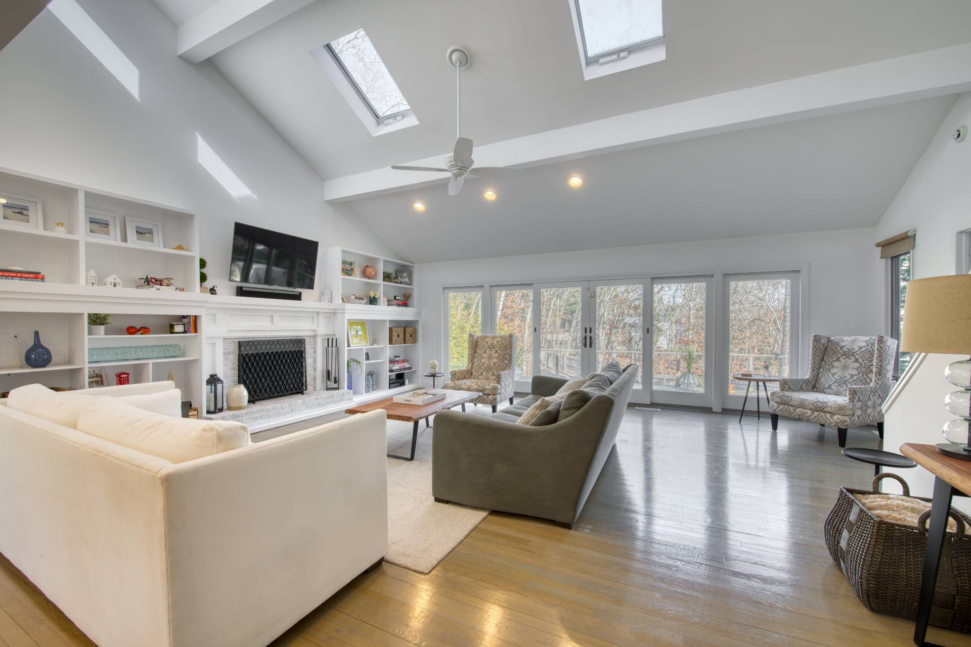 10 Scallop Avenue East Hampton, NY 11937 - Photo 4 of 23 a living room with furniture a fireplace and a flat screen tv