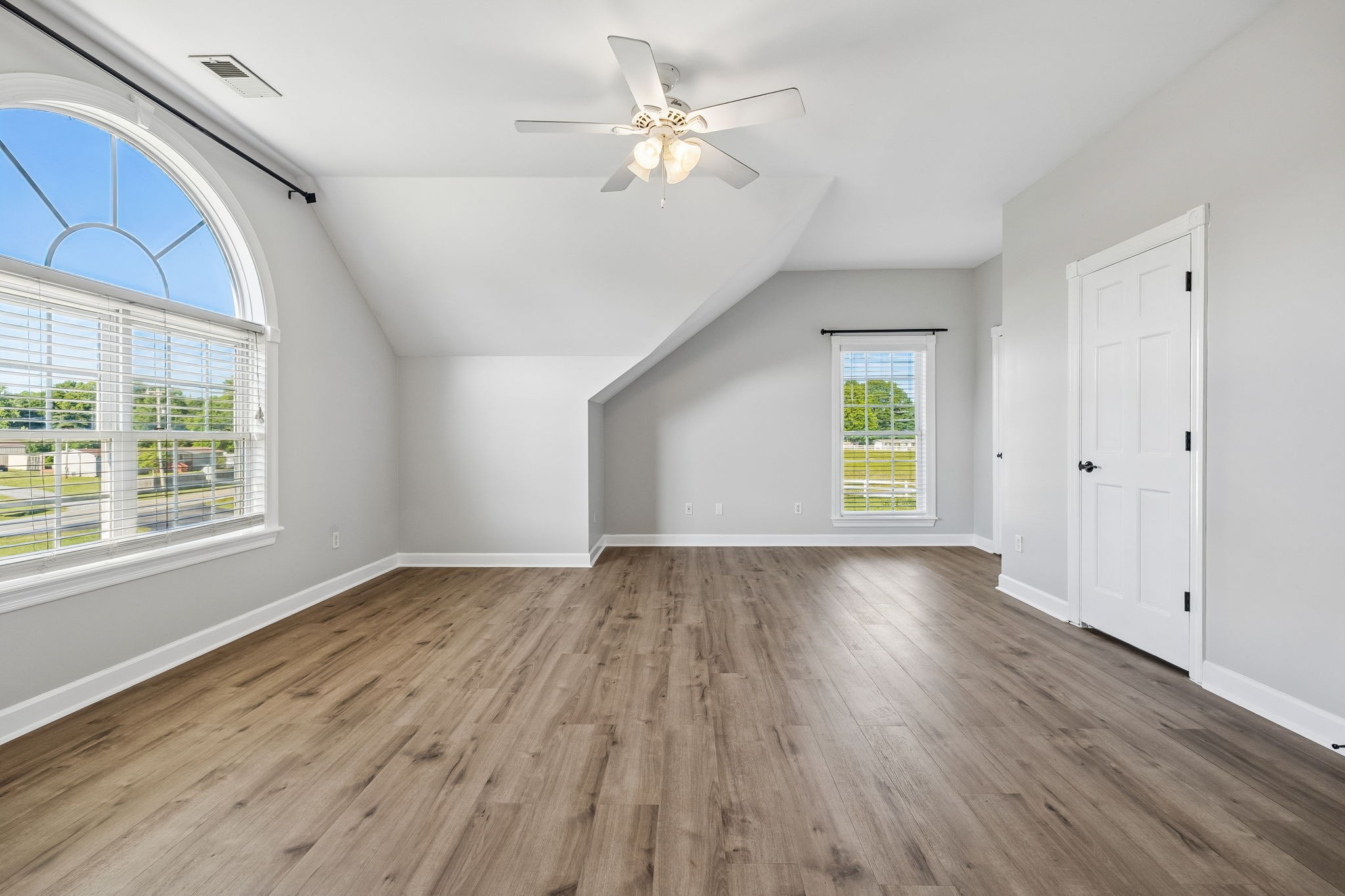 100 Heath Road Charlotte, TN 37036 - Photo 32 of 42 an empty room with wooden floor chandelier fan and windows