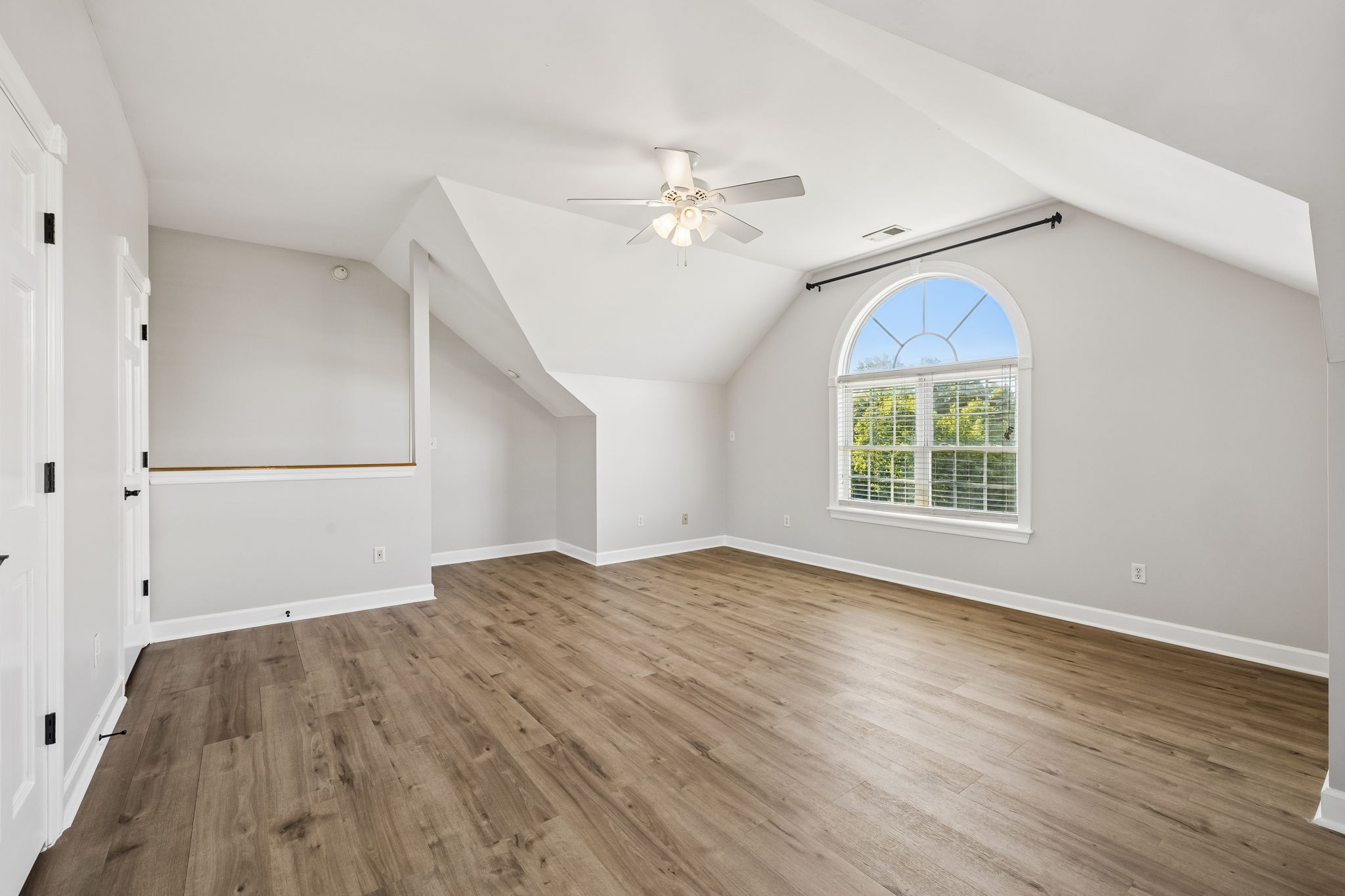 100 Heath Road Charlotte, TN 37036 - Photo 34 of 42 an empty room with wooden floor chandelier fan and windows