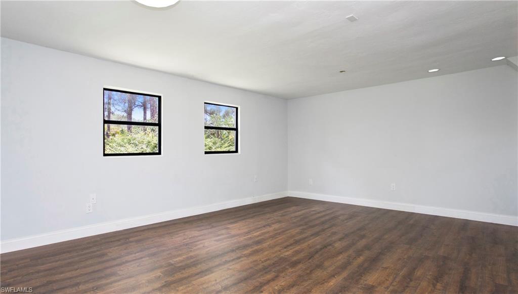6640 Trail Boulevard Naples, FL 34108 - Photo 11 of 25 an empty room with wooden floor and window