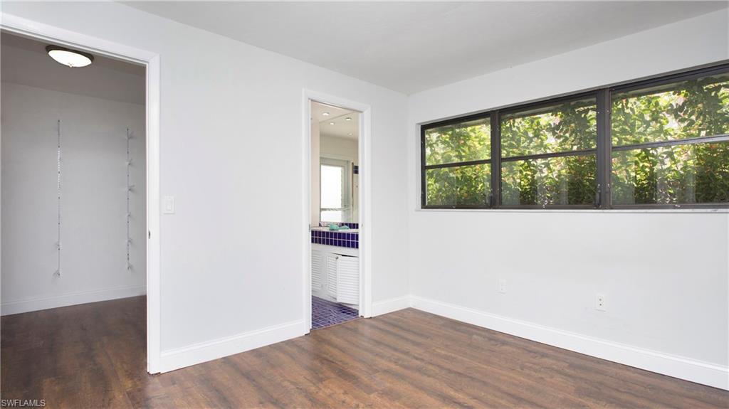 6640 Trail Boulevard Naples, FL 34108 - Photo 12 of 25 an empty room with wooden floor and windows