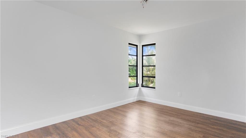 6640 Trail Boulevard Naples, FL 34108 - Photo 13 of 25 an empty room with wooden floor and windows