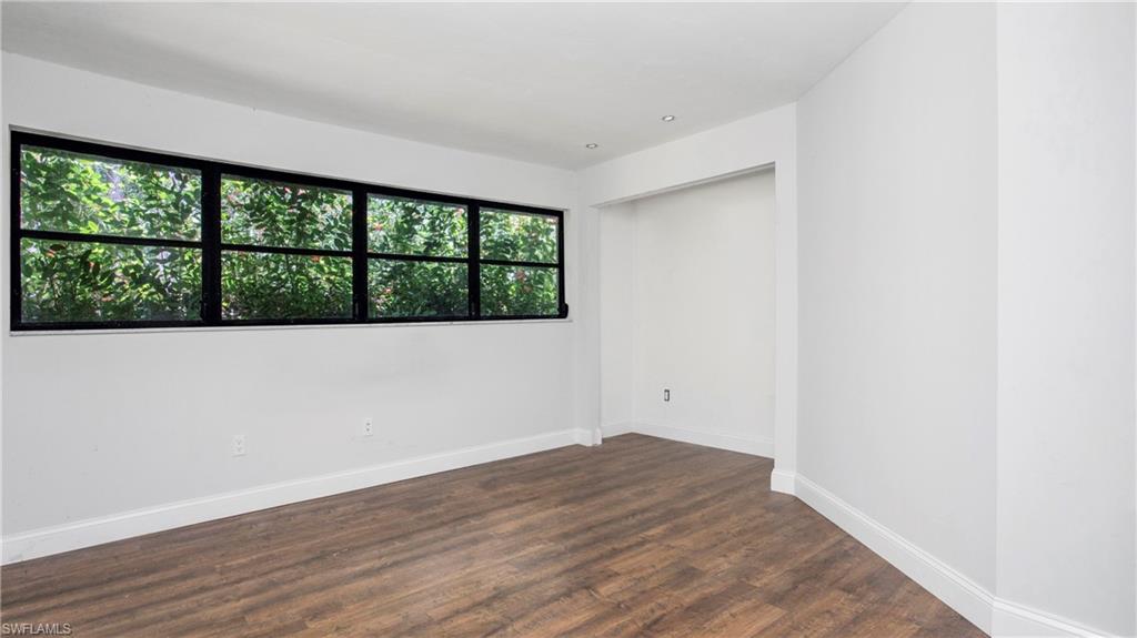 6640 Trail Boulevard Naples, FL 34108 - Photo 14 of 25 an empty room with wooden floor and windows