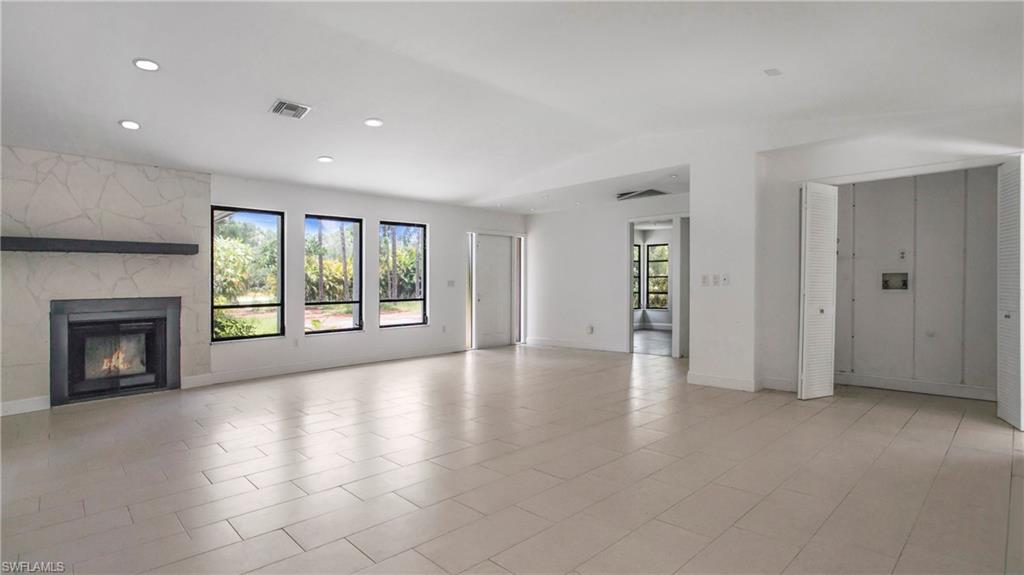 6640 Trail Boulevard Naples, FL 34108 - Photo 6 of 25 an empty room with windows and fireplace