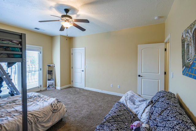 3683 South 2640 West St. George, UT 84790 - Photo 31 of 41 Spacious room featuring carpet flooring, a ceiling fan with integrated lighting, and multiple windows with blinds