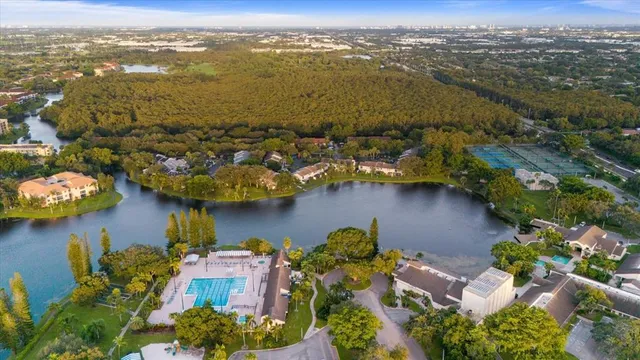 an aerial view of ocean and residential houses with outdoor space