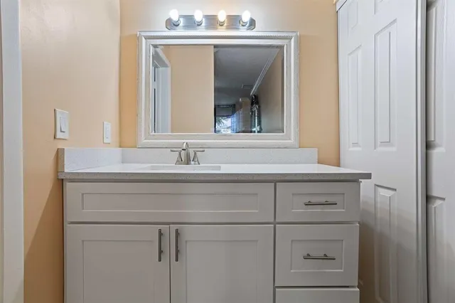 a bathroom with a sink vanity and mirror