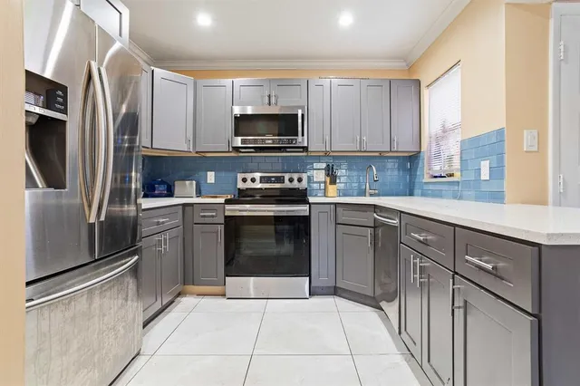 a kitchen with stainless steel appliances granite countertop a refrigerator sink and microwave