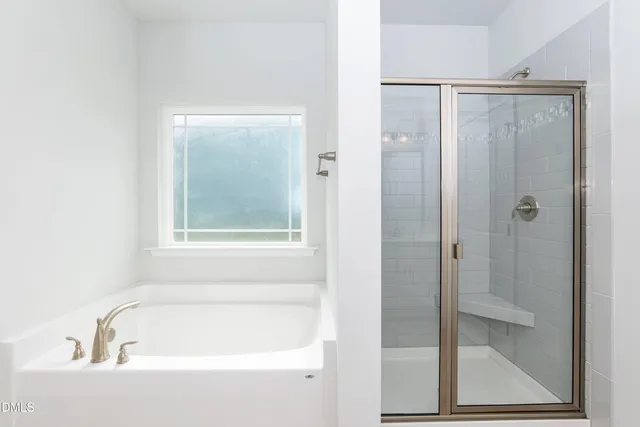 a white bath tub sitting next to a shower