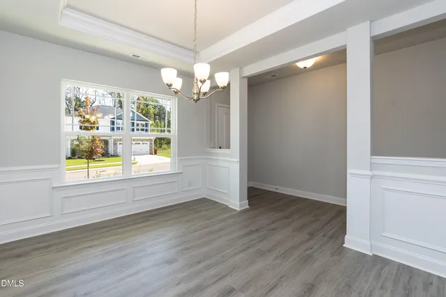 a view of a dining room with furniture a chandelier and wooden floor