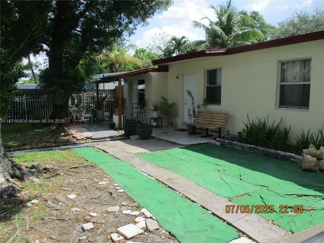 a view of a backyard with plants and a patio