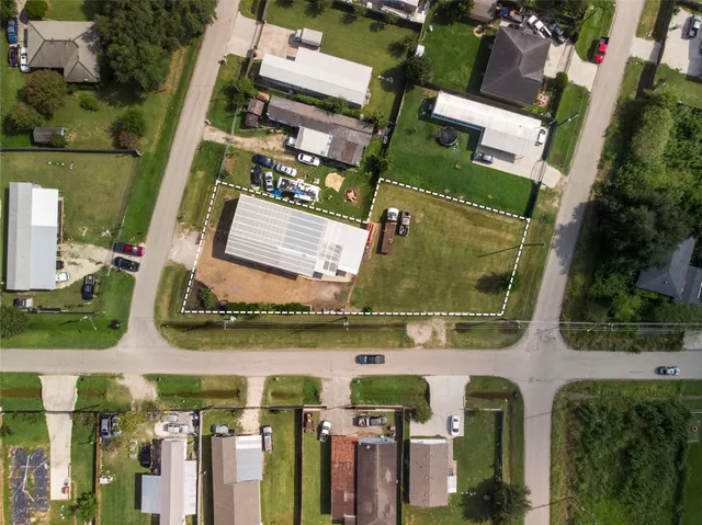 an aerial view of residential houses with outdoor space and parking