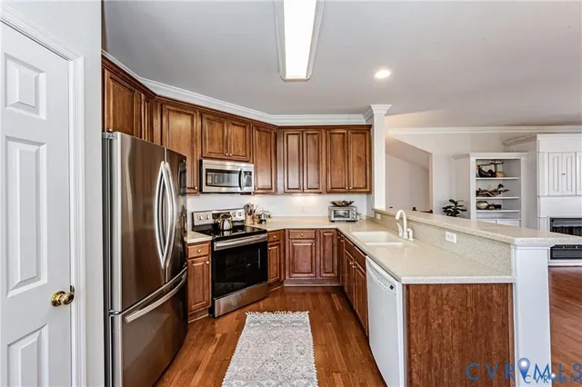 a kitchen with stainless steel appliances granite countertop a refrigerator a sink dishwasher a stove with white cabinets and wooden floor