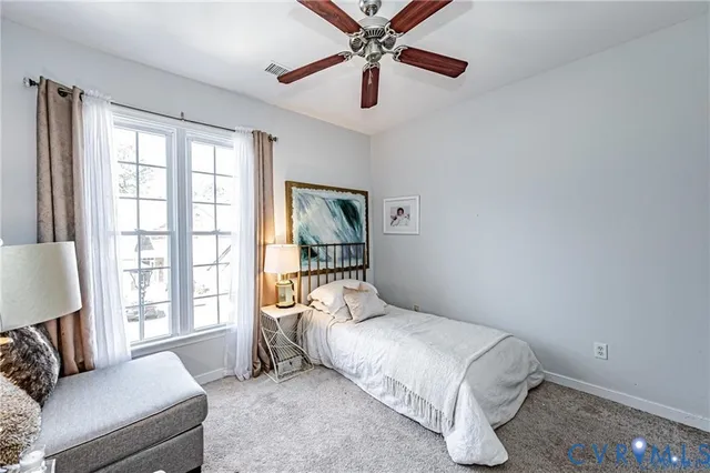 a bedroom with a bed ceiling fan and a window